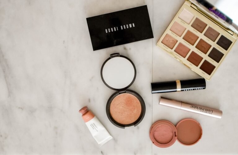 A close-up of a woman applying natural makeup in a bright, soft-lit environment, showcasing a fresh and minimal look.