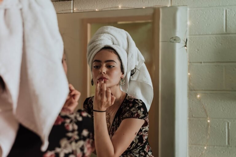 A close-up of a person applying skincare products with a thoughtful expression, surrounded by various skincare items like creams and serums.
